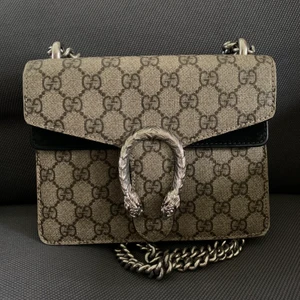 Gucci Dionysus  - Säljer min Gucci Dionysus small väska. Tyvärr har väskan blivit av med en liten bit av tyget på framsidan, men som tur är så täcker låset mycket av det bort skavda. I hörnen på väskans framsida är det också lite slitet. 