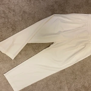 Vita vida byxor.  - Vita vida byxor i fint material. Helt perfekt skick. Använda en gång pga fel storlek. Hög midja och veck framtill. Skrynklar ej. 