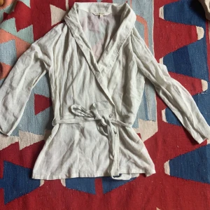 Grön knytblus - Ljusgrön blus som man kan knyta med band. Går att ta ut bandet och bara knäppa med knapparna. Lite genomskinlig.