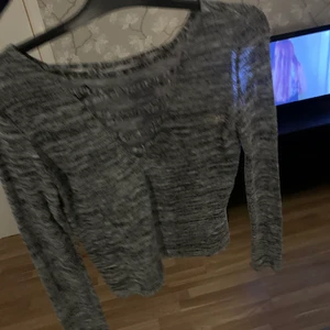 Grå långärmad tröja med urringning  - Fin gråspräcklig långärmad tröja. Lite urringning med ”snörning” över. fint skick, storlek M