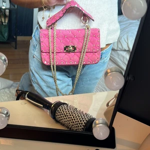 Valentino väska - Valentino rockstud väska. Den lilla modellen.  Säljer nu min valentino rockstud väska. Dustbag och äkthetsbevis finns. Ett litet märke på den annars sparsamt använd och i ett fint skick. Guld/rosa. Köpt på vestiarie collective. 