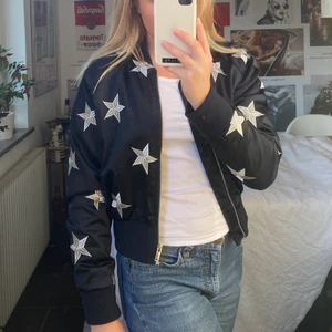Jacka med stjärnor - En skitsnygg jacka i marinblå färg med broderade stjärnor på. Bra kvalite, relativt varm och framförallt unik