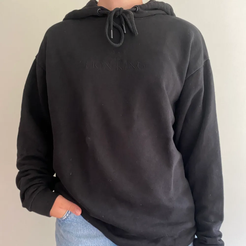 En svart hoodie med lejonkungen motiv på ryggen. Den har inga fickor. Använd 1-2 gånger. Du står själv för frakten💕. Hoodies.