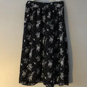 Svart blommog kjol som jag köpte för några år sedan men har blivit alldeles för liten på mig som är 173. Den är i mycket bra skick och perfekt för sommaren men som sagt har väldigt liten midja. Skriv om du undrar något💗