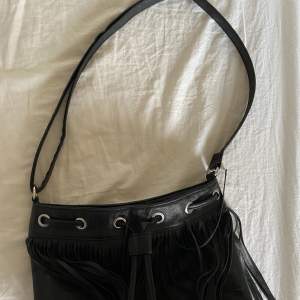 En snygg svart väska med fransar från okänt märke. Pris kan diskuteras💕