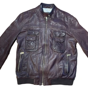 Läderjacka  - Köpt secondhand men i jättebra skick!! 100% äkta skinn. Jackan är i storlek M men skulle säga att den känns som en S. Färgen syns bäst på bild 2!! 