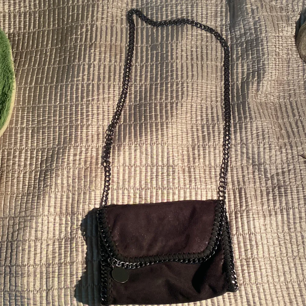 Säljer nu min svarta väska som liknar en tiamo väska (men är inte det). Jag säljer denna för jag inte använder den alls längre. Jag fick den för ett år sedan så jag skulle säga att den är i bra skick (inget har gått sönder)! En svart väska med kedja! . Väskor.