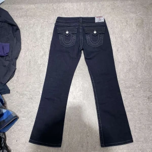 Vintage bootcut true religion becky - Ett par fina mörblåa/svarta bootcut true religions med flaps och vit stitch👌använd gärna köp  nu och kolla in min profil👍 kommer säljer fler bootcut true religions. pris kan alltid diskuteras😊 tveka inte att skriva om du har några frågor