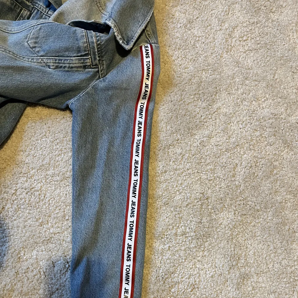 Jeansjacka från Tommy jeans i strl S i en blå-blå färg. Denna jacka har aldrig blivit använd tyvärr då jag har andra, men den sälj inte längre vad jag kan se och är en ovanlig modell. Ganska slim fit strl (inte en oversized fit) och värd ca 1400kr. . Jackor.