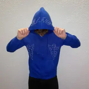 Blå hoodie designat med Rhinestine, finns även i en svart modell!