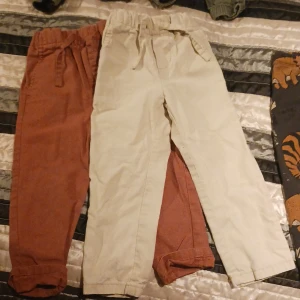 2 chinos barn - 1 biega och 1 orange/röda i storlek 92 från lindex, oanvänt skick.