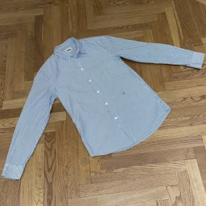 Acne Skjorta - Slim Stripe 2 SS11 - Acne Slim Stripe 2 skjorta från SS11 kollektionen. Skjortan är i väldigt bra skick med tanke på dess ålder, och har inget synligt slitage. Vid intresse så kan jag skicka fler bilder. Storlek: 46 / Small Passform: Slim