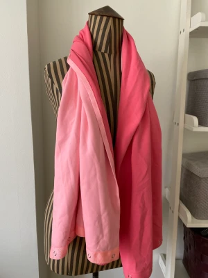 Härlig sjal från Lululemon - Jättefin sjal/halsduk från Lululemon. Olika rosa färger på vardera sida och knappar i kortändorna för att kunna göra olika sorters knytning. Funktionsmaterial. 