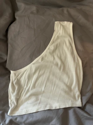 Fin one shoulder topp - Helt oanvänd one shoulder topp. Något genomskinlig men funkar med vit eller röd bh. Från shein strl xs. Säljer för 25kr.