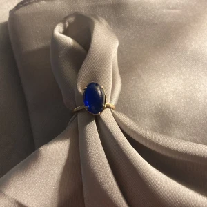 Blå ring  - Guldig ring med en blå pärla 