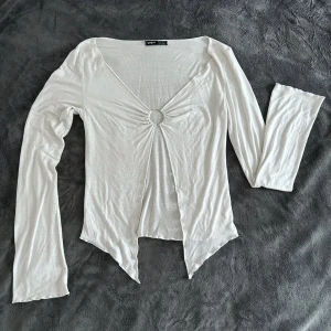 Somrig topp med detalj - Topp från SHEIN i tunnare material, perfekt för sommarvärmen. En silverring i mitten, visar mage och nyckeben.