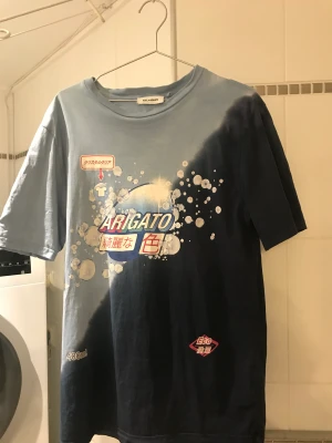 Arigato Tshirt - Blå Arigato T-shirt med tryck på magen. Kommer inte till användning längre. Köparen står för frakt📦