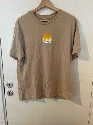 Beige t-shirt från Lee med tryck både fram och bak. Endast använd 1 gång😊