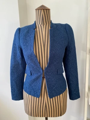 Blå kavaj från H&M - Snygg kavaj från H&M. Blå med fint mönster. Fint skick men något skrynklig. Lite liten i storlek, passar XS.