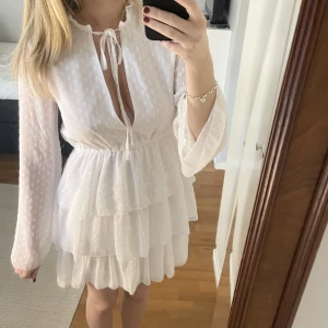 Vit klänning  - Säljer min klänning från NA-KD x Linn Ahlborg kollektionen, perfekt till studenten! Bra skick förutom en liten missfärgning på ena ärmen (se bild 3) men det syns knappt! 💕