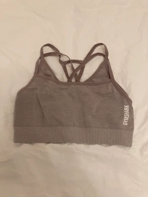 Gymshark sport-bh  - Sport-bh från gymshark, kollektionen ”adapt marl” i en dov lila-grå färg. Måttligt använd men syns lite på axelbanden att den har använts. Nypris 449kr