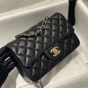 CHANEL FLAP MINI BAG - Helt ny väska i modellen Mini Flap Bag med guld detaljer, ej äkta men i äkta läder därav priset. Nypris för äkta ca 50 tusen. 