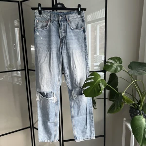 Jeans  - Raka ljusblå jeans från H&M med hål i knäna. Jeansen är i storlek 34 men passar Xs och S