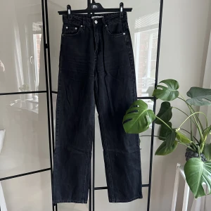 Jeans  - Jeans i tvättad svart från Nakd i storlek 34. Jeansen är vida och mellanhöga i midjan