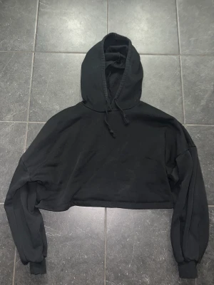 Svart croppad hoodie - Säljer en svart croppad hoodie från GinaTricot i storlek S, pris 120kr