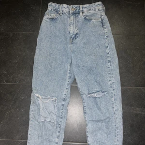 Jeans med hål - Blåa jeans med hål från HM i storlek 34, pris 150kr