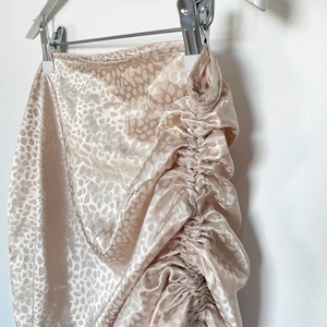 Festlig kjol - Champagne färgad & mönstrad festligt kjol från Shein. (aldrig använd) Den går att justera längd på både sidor beroende på hur man vill styla den.   Den är tunn och luftig, ser jättefint ut när man har på sig den på kroppen. Sann till storlek men passar M om man är mer kurvig! 