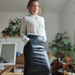 Kjol ormskinn - Svart fake ormskinn. Fickor. Dragkedja i sidan och resår där bak i midjan. Aldrig använd. XS men är nog mer S