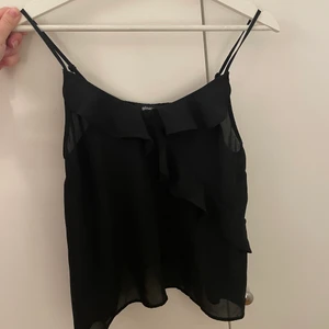 Svart linne från Gina Tricot - Svart linne med volang från Gina Tricot. Fint skick! 60 + frakt