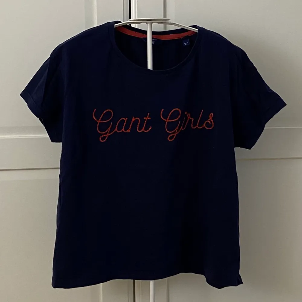 En mörkblå t-shirt från Gant med applikation💙Applikationen är en broderad text som det står ”Gant Girls”. Passform/Storlek är från 13y uppåt men skulle säga runt en S. Pris går att diskutera . T-shirts.