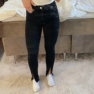 Jeans med slits från NAKD - Svarta jeans med en söm längst fram på benet samt slits längst ner. 150kr. Storlek 34. Möts upp i Halmstad eller så står köparen för frakten.🖤