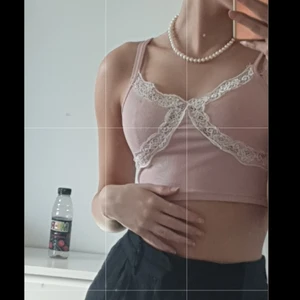 Rosa topp - Jättesöt rosa kort topp, med spets som ett kryss på framsida. Den är köpt från shein så materialet är självklart inte i topp kvalitet, men tröjan i sig är inte trasig på något sätt. Väldigt fin att använda nu på sommarn när man ska till stranden eller på picknick.