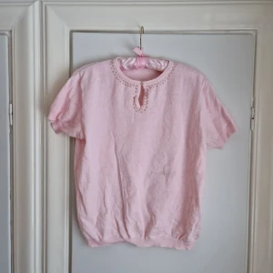 Vintage finstickad tröja med paljetter  - Vintage finstickad tröja i underbar ljusrosa färg. Paljetter kring kragen. Uppskattas till stl M/L/40/42 men passar säkert 38 också. Stretchigt material. 