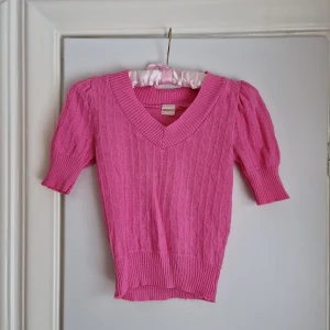 Vintage finstickad tröja  - Liten och tjusig finstickad tröja i syntetmaterial.  Märkt med stl 150, vilket är barnstorlek. Kan även bäras av xs/s. Materialet är stretchigt.  Jämn, rosa färg. Inget synbart slitage utöver en liten förtunning på ruggen, cirka 3 x 3 mm. Knappt synbart.