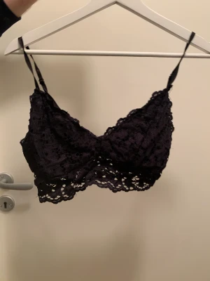 Bralette i spetsmaterial - Svart bralette i spetsmaterial. Använd ett fåtal gånger men som nyskick. Justerbara axelband, ingen knäppning