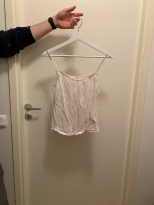 Vitt linne - Vitt linne med lite v-skärning fram. Kan användas åt båda hållen, skärningen fram eller bak. Tunnare material.