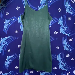 Blå-grön klänning i satin-liknande material. 