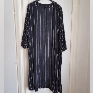 Kaftan med slits Monki - Tjusig och snyggt fallande kaftan i 100% Viscose. Använd någon enstaka gång.  Sval och skön om sommaren. Passar även resten av året då den har lite tyngd och känns rejäl. Passar M-XL / 40-46 Är märkt med M 