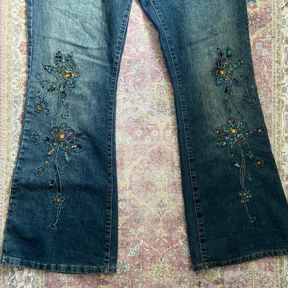 suuupersnygga lågmidjade utsvängda jeans med paljett/pärldetaljer på benen. En liten slitning längst ner på ena benet men annars är det så gott som nya. Stl 36!. Jeans & Byxor.