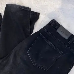 Ett par missguided jeans i svart färg, jeansen är bootcut och har slits. 