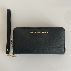Michael kors plånbok  - Trevlig miniväska/plånbok att ha med sig när man går ut. Bra skick! Nypris 2000:- 