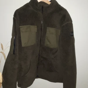 ANERKJENDT GRÖN FLEECE JACKA - Anerkjendt grön fleece jacka. Nypris 1200. Använd sparsamt. Vadderad inuti så är mer åt ytterplaggshållet än crewneck/hoodie. Mitt pris 400