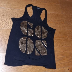 Linne med guld Gina Tricot  - Svart Linne med guldtext och paljetter. 