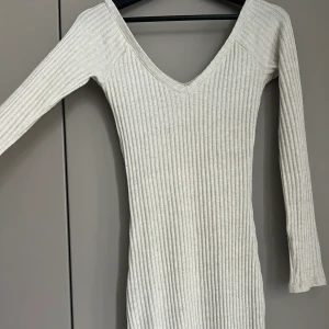 Ribbad klänning  - Figursydd och ribbad tight klänning , lite längre me slits.  