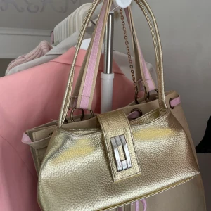 Guldig väska🌞💛⚜️👑 - Säljer denna fina guldiga väskan som tyvärr inte kommer till användning för mig. Väskan är köpt från humana second hand och är i otroligt bra skick!  Obs: frakt tillkommer! Skriv gärna till mig för flera bilder eller andra frågor, svarar gärna!