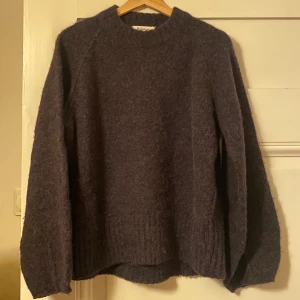 Rodebjer Stickad, L - Alpackastickad tröja från Rodebjer som inte används! Endast använd 2 gånger men såg nu att en tråd har släppt i halsen. Superlätt att fästa igen med lite svart tråd dock! Lite ”tvättad svart” i färgen. Har i L för oversized fit! Köpare står för frakt.